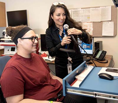 Speech-language pathologist Deborah Vega works with Kaytlin Marquess to help her improve her respiratory support for speech, resonance, pitch range, and loudness levels.