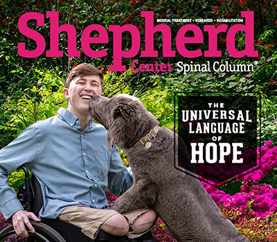 Shepherd alum Daniel Hund, who uses a wheelchair after sustaining a spinal cord injury, a traumatic brain injury and having both legs amputated above the knee, gets a sloppy kiss from his dog, Olaf.
