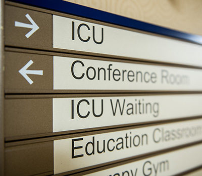 A hallway sign at Shepherd Center that directs people to the ICU, Conference Room, ICU Waiting, Education Classroom, and Therapy Gym.