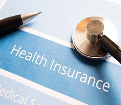 A health insurance form with a stethoscope and pen beside it,