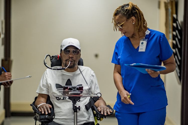 Patient using wheelchair alongside Shepherd Center nurse