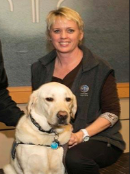Facility dog, Frosty, sits with his handler, Rebecca McWalters.