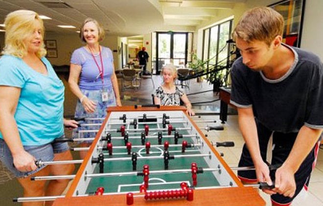 Group of people playing foosball in Shepherd Center housing common area