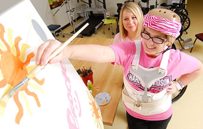 Adolescent patient paints canvas as part of Shepherd Center's Recreation Therapy program