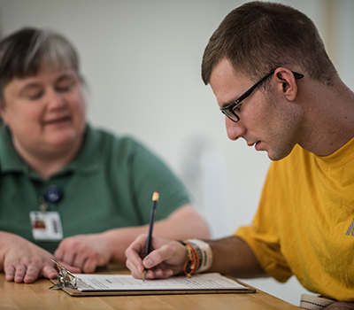 Cole Burton, who sustained a brain injury, works with speech therapist Amy Waite.