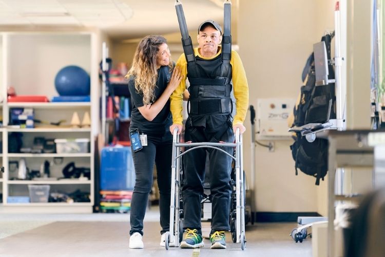 John Davis works with Physical Therapist Taylor Galmarini during a physical therapy session using the  ZeroG® Gait and Balance System. 