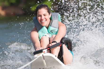 Camp ASW participant riding water ski through lake