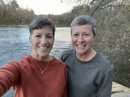 Catherine McLean poses for a picture with her partner, Debbie Mosure, by a lake. 