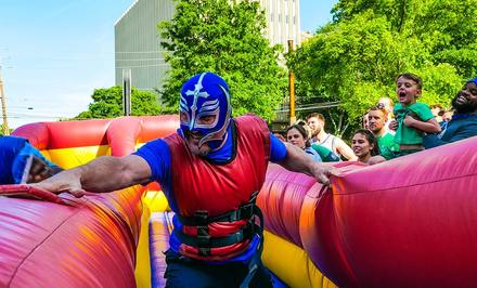 A man dressed as a superhero races to complete an inflatable obstacle course