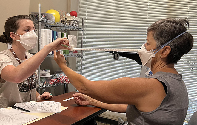 Occupational therapist Bekah Odom (L), completes a visual screening to see how Catherine McLean's eyes are working together.