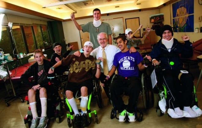 A group of adolescents and teens make silly faces while seated in their wheelchairs.