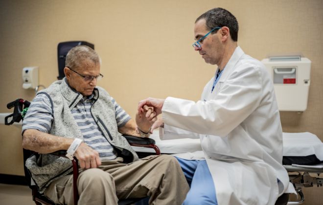 Doctor in the Rehabilitation Medicine Clinic checks the spasticity in a patient's hand and wrist