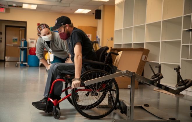 Patient with spinal cord injury performs rehabilitation exercises with physical therapist