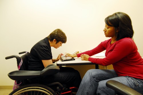 Speech-language pathologist Lateia Scott leads stroke patient Kristie Tant, right, in speech therapy using an iPad