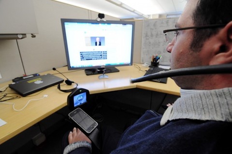Jason Disanto, seated at his desk, uses assistive technology to complete a task a work.
