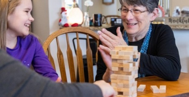 Sybil Williams claps in excitement as she plays a game of Jenga with her granddaughter